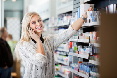 customer using phone while picking up pharmacy product